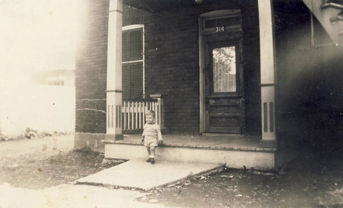 Bambin devant une maison