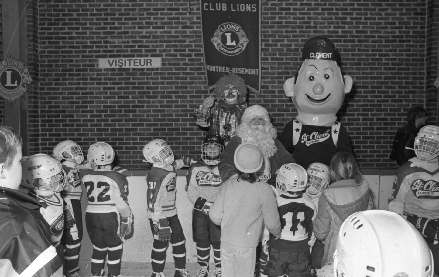 Équipe de hockey mineur St-Clément avec un clown, la mascotte Clément et le père Noël
