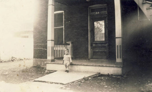 Bambin devant une maison