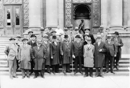 Groupe d'hommes portant imperméables et chapeaux