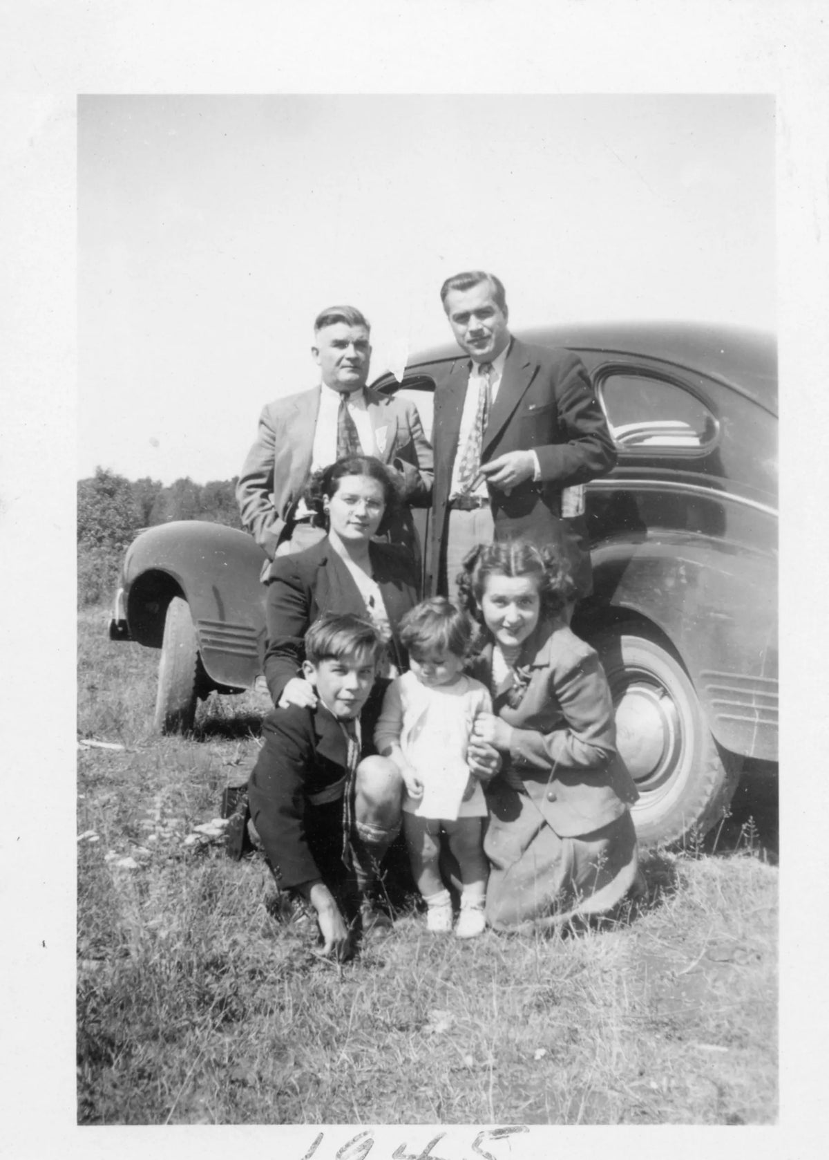 3 générations près d'une voiture